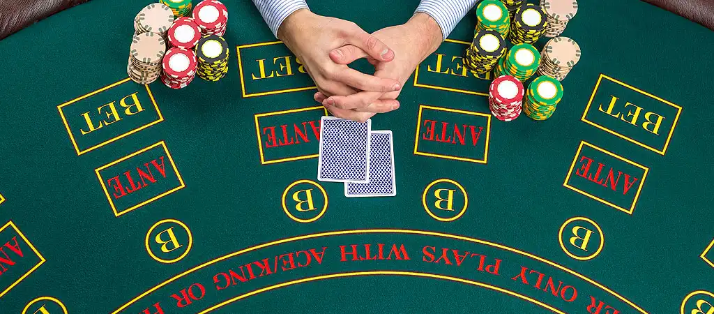 Blackjack játék kezdő lapjai zsetonokkal az asztalon.
