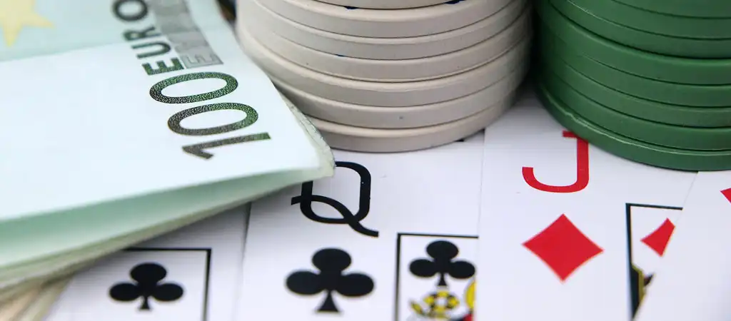 Kártyalapok, zsetonok és euró bankjegyek egy kaszinó bankroll menedzsment bemutatásához.
