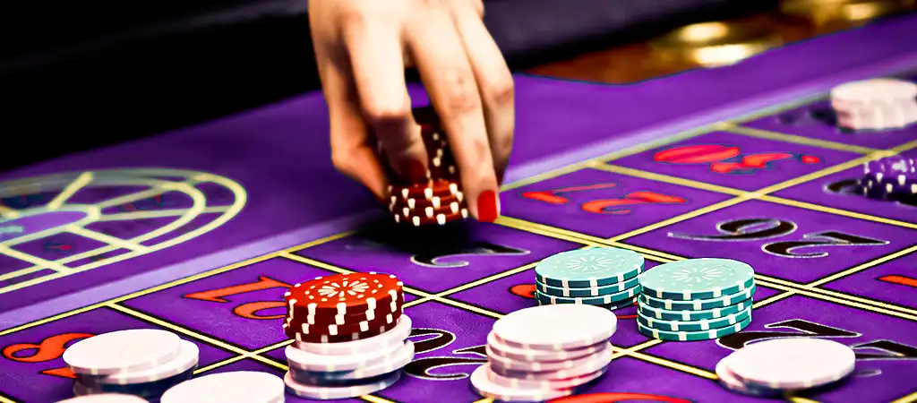 K&eacute;z, amely zsetonokat helyez egy rulettasztalra, a gambling vagyis a szerencsej&aacute;t&eacute;k izgalm&aacute;t &eacute;s strat&eacute;gi&aacute;j&aacute;t szimboliz&aacute;lva.