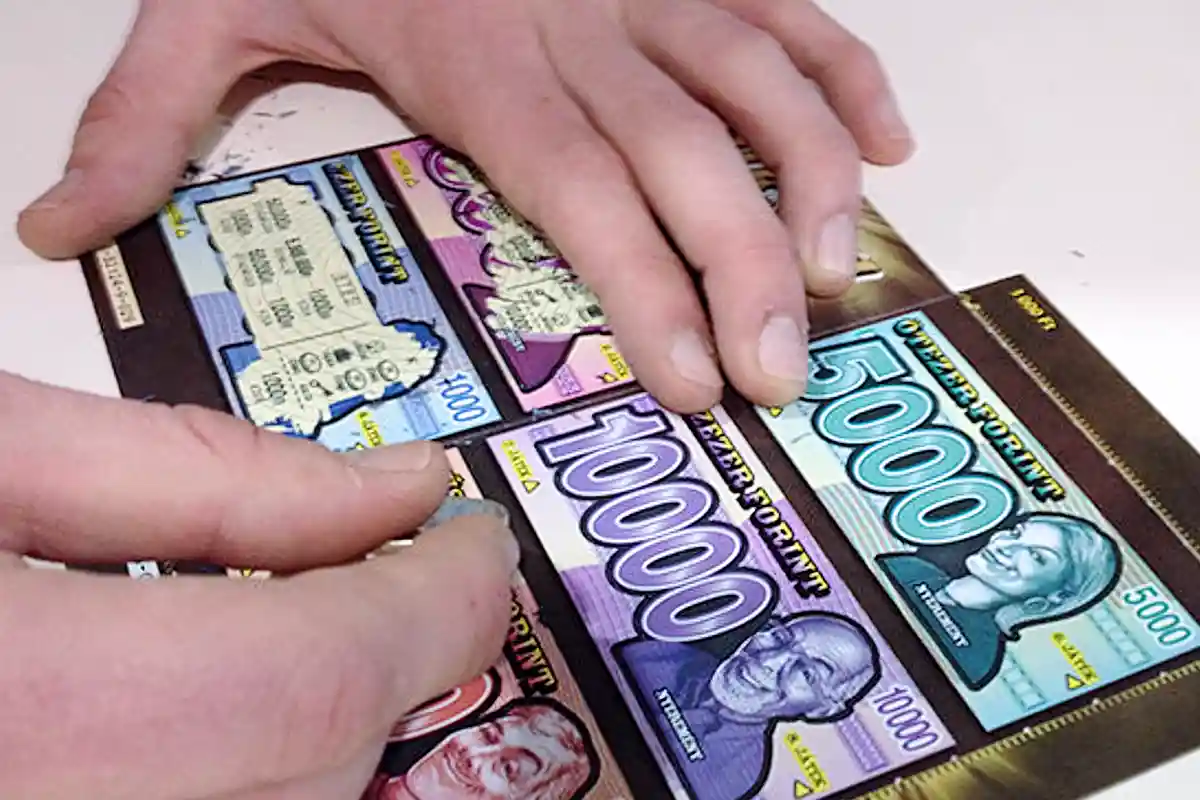 Buksza kapar&oacute;s sorsjegy lekapar&aacute;s k&ouml;zben, p&eacute;nznyerem&eacute;nyek felt&uuml;ntetve 1000 &eacute;s 10 000 forint k&ouml;z&ouml;tt.