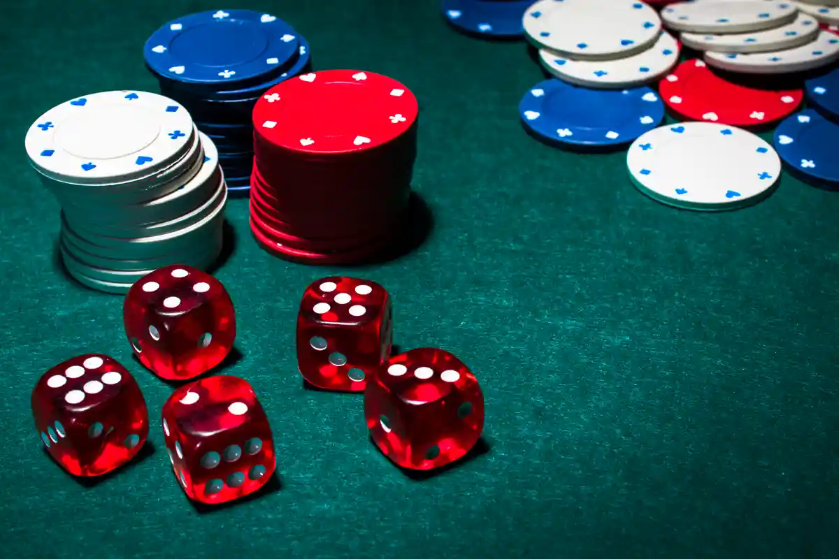 Kockák és zsetonok zöld kaszinóasztalon, a gambling jelentése vizuálisan bemutatva.