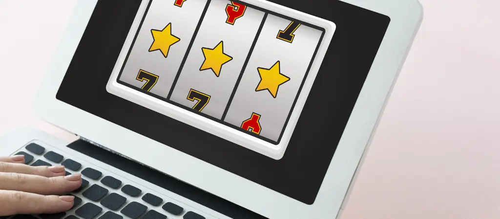 Online szerencsejátékot ábrázoló laptop kijelző nyerő szimbólumokkal és digitális kaszinó grafikával
