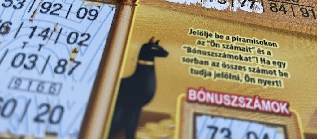 Kaparós sorsjegy részlete betűs és számos mezőkkel, amelyek a nyeremények és a kifizetések közötti összefüggést szemléltetik a játék felületén